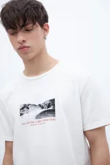 Remera blanca de algodón con cuello redondo y manga corta. Estampado fotográfico en el pecho con texto.