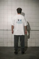 Remera blanca de algodón con cuello redondo y estampado pequeño en el pecho.