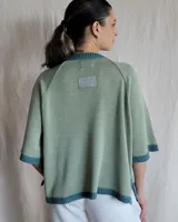 Sweater color beige de tejido de punto con mangas cortas y cuello redondo.