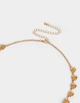 Collar corto dorado con dije de girasoles bañado en oro, con cadena de eslabones y cierre de mosquetón con cadena de alargue.
