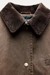 Trench color verde oscuro con cuello solapa combinado en pana marrón y manga larga. Detalle de acabados con trabillas y pinza en espalda. Bolsillos delanteros con solapa y botón a presión. Tejido encerado efecto lavado. Cierre frontal con botones a presión.