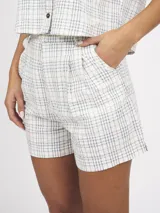 Short de tiro alto con estampado a cuadros azules y blancos, con bolsillos laterales y pinzas en la cintura.