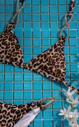 Bikini con estampado de animal print en tonos marrón y negro, con detalle de tirantes metálicos.