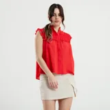 Falda corta beige con botones frontales y diseño ajustado.