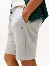 Pantalón corto deportivo gris de felpa, con cintura elástica ajustable con cordón, bolsillos laterales y logo de Tommy Hilfiger bordado en el ruedo.