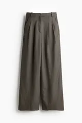 Pantalón ancho de vestir con estampado a cuadros en tonos marrones y negros. Modelo de tiro alto con elástico oculto en la cintura y cierre. Bolsillos al bies, bolsillos decorativos insertados atrás y piernas rectas amplias con pliegues adelante.