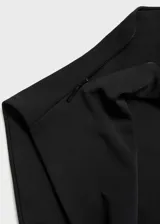 Vestido largo negro de tejido elástico con cuello drapeado y abertura lateral.