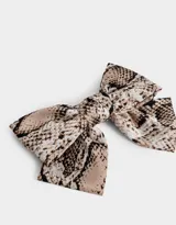 Hebilla francesa con moño grande de tela con estampado de piel de serpiente en tonos beige, marrón y negro.
