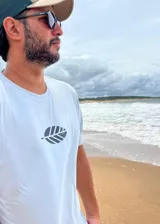 Remera celeste de corte clásico con cuello redondo y manga corta. Estampado pequeño en el frente de una hoja estilizada en color gris oscuro.