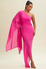 Vestido largo de fiesta fucsia, con un solo hombro y manga larga tipo capa. Tiene un corte ajustado con drapeado en la cintura y abertura lateral en la falda.