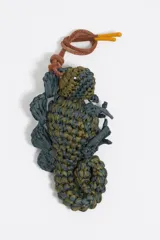 Colgante para bolso con forma de lagarto tejido en rafia color verde y gris.