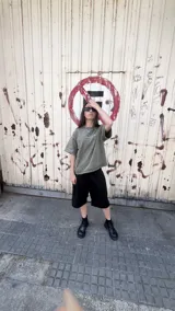 Bermuda negra de corte holgado con cintura doble. La cintura interior es elástica y presenta un estampado de camuflaje tipo bosque (Realtree). Posee cordón de ajuste frontal.