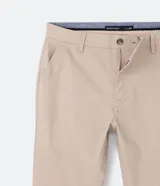 Pantalón de vestir azul marino, de corte recto, con bolsillos laterales y traseros. Se ajusta a la cintura con cinturón de cuero marrón.