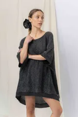 Vestido-buzo tejido de silueta oversize con hilado jaspeado en brillo, escote redondo, mangas amplias tipo murciélago y terminaciones acanaladas en ruedo y puños.