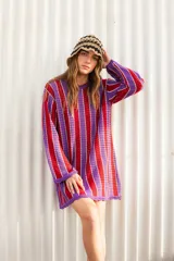 Vestido corto tejido a crochet, con rayas verticales rojas y violetas.