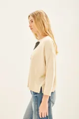 Sweater color crema con estampado de flor en tonos grises y negros en el frente.
