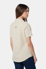 Camisa de lino color beige, de manga corta, con medio botón, dos bolsillos en el pecho y botones metálicos personalizados.