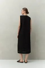 Vestido largo color beige, sin mangas, confeccionado en algodón con calados verticales y bordado tipo ojo de perdiz.