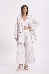 Top crop blanco con estampado de dibujos en tonos grises y marrones, con escote en V y breteles anchos.