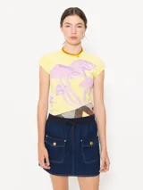 Minifalda de denim azul oscuro con cintura elastizada y cordón ajustable. Tiene dos bolsillos delanteros con solapa y botón dorado.