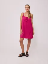 Vestido corto de algodón y lino color negro, con tirantes finos y escote recto con lazo ajustable.