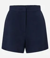 Short de tiro alto color azul marino, con cintura de sastrería, elástico en la parte trasera, bolsillos laterales y cierre tradicional. Confeccionado en tejido airflow.
