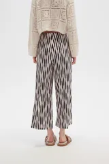 Pantalón recto de poliéster con estampado a rayas verticales en blanco y negro.