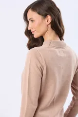 Buzo tejido de lana color beige con cuello alto, calce cómodo y diseño minimalista. Presenta puños y ruedo acanalados, con una pequeña etiqueta de marca aplicada en el lateral.