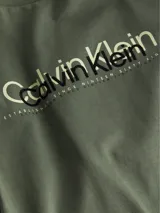 Remera verde militar de manga corta y cuello redondo. Estampado frontal con el logo de Calvin Klein en blanco y negro y la leyenda "Established since nineteen sixty eight".