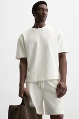 Camiseta negra de corte holgado, con cuello redondo y mangas cortas.