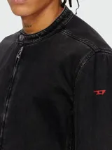 Campera negra de denim con cuello mao y cierre frontal. Diseño tipo trucker o cazadora, con puños y cintura ajustados con costuras visibles.