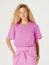Blusa color rosado con mangas cortas abullonadas y cuello redondo.