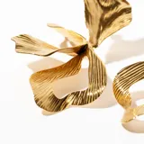 Aros colgantes con forma de flor en color dorado, con textura acanalada.
