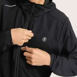 Campera negra con capucha, ultraliviana y plegable, con cierre frontal y logo estampado en el pecho.