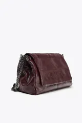 Bolso de hombro marrón oscuro de cuero sintético, con solapa y cierre magnético. Tiene un asa de cadena plateada y tres compartimentos internos, uno de ellos con cierre de cremallera.