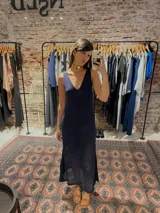 Vestido largo tejido de color azul marino, con escote en V, sisa profunda y calado en la parte inferior.