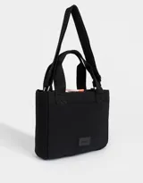 Cartera bandolera negra de tela deportiva con doble asa corta de mano, correa regulable y desmontable, cierre superior y tag de goma con logo.