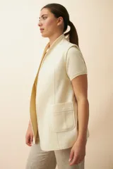 Chaleco color beige, entallado, con solapa, bolsillos plaqué y terminaciones envivadas.