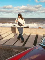 Riñonera de cuero color borgoña con correa ajustable.