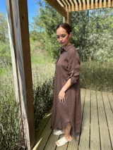 Vestido camisero largo de lino blanco, con corte en la cintura, abertura lateral y botones de nácar.