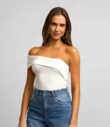 Blusa corta de jersey color blanco, con escote asimétrico de hombro único y canesú plegado en el busto.