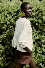 Blusa rústica color crema de cuello redondo con cordón, escote pico y manga larga acabada en elástico. Detalle de tejido combinado en crochet en mangas y parte superior del frente.