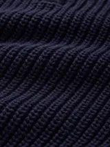 Sweater azul marino de tejido de punto grueso, con cuello polo con cierre de media cremallera y logo bordado en el pecho.