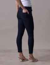 Jean skinny de tiro medio, color azul oscuro, con pretina con pasadores, botón y cierre.