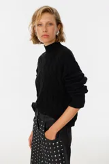 Sweater color beige con diseño de trenzado y cuello alto, de corte holgado.