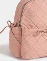 Mochila rosa claro de tela deportiva acolchada con diseño de rombos. Tiene asa de mano, correas regulables, cierre superior, bolsillo frontal con lazo decorativo y bolsillos laterales con lazos.