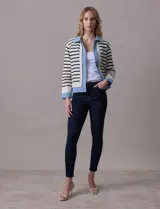 Campera combinada marca Nanette, con torso y mangas en tejido a rayas horizontales blancas y negras. Solapa, puños y cierre en denim celeste. Cierre frontal con botones metalizados.