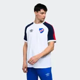 Remera de algodón blanca con mangas cortas ranglan azul marino con una franja roja en el hombro. Tiene el logo de Umbro bordado en el pecho y el escudo del Club Nacional de Football.
