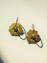 Aros de acero con forma de flor color azul con glitter y centro dorado con strass. Diseño 2en1 con doble flor de distinto color en cada lado.