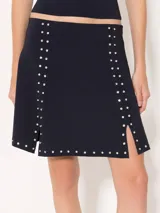 Pollera marrón tejida con calce al cuerpo, de largo arriba de las rodillas y detalle de tachas plateadas.